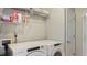Bright laundry room with white Amana washer and dryer, wire shelves, and neutral walls at 424 Crystal Spring Dr, Sanford, NC 27332