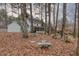 Backyard featuring a screened-in porch, bench, and lawn covered with leaves and trees at 48 Margaret Pl, Chapel Hill, NC 27516