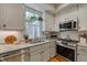 Charming kitchen with white cabinets, granite counters, and modern stainless steel appliances at 48 Margaret Pl, Chapel Hill, NC 27516