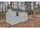 A storage shed sits in the backyard amongst the trees and fallen leaves at 48 Margaret Pl, Chapel Hill, NC 27516
