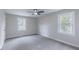 Bright bedroom features neutral carpet, a ceiling fan, and double windows at 4814 Fayetteville Rd, Durham, NC 27713