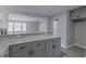 An open kitchen with granite countertops and gray cabinets leads to the bright and airy living room at 4814 Fayetteville Rd, Durham, NC 27713
