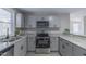 Updated kitchen with gray cabinets, granite countertops, and stainless steel appliances at 4814 Fayetteville Rd, Durham, NC 27713