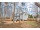 View of the home's spacious, fenced backyard featuring mature trees and landscaping at 507 Town Crier Ct, Hillsborough, NC 27278