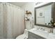Well-lit bathroom featuring a patterned shower curtain, modern vanity, and decorative shelving at 507 Town Crier Ct, Hillsborough, NC 27278