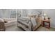 Cozy bedroom with white wooden bed frame, sitting sofa, and large window providing natural light at 507 Town Crier Ct, Hillsborough, NC 27278