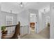 Upstairs hallway with carpet and wooden railing provides access to bedrooms and other living spaces at 507 Town Crier Ct, Hillsborough, NC 27278