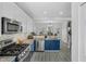 Bright kitchen with stainless steel appliances, bar seating, blue cabinets and open floorplan at 507 Town Crier Ct, Hillsborough, NC 27278