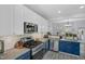 Open kitchen with stainless steel appliances, blue cabinets, stone backsplash, and eat-in bar at 507 Town Crier Ct, Hillsborough, NC 27278