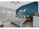 A calming main bedroom with a vaulted ceiling, large windows, and a striking blue accent wall at 507 Town Crier Ct, Hillsborough, NC 27278