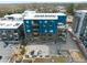 Aerial view of a modern blue building with balconies and parking, surrounded by lush greenery and urban landscape at 515 N Mangum St # 14, Durham, NC 27701
