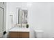 Powder room with white paneled walls, wood vanity, marble top, and decorative mirror at 5213 Bent Leaf Dr, Raleigh, NC 27606