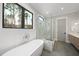 Bright bathroom featuring a soaking tub, glass enclosed shower, and natural light from a nearby window at 5213 Bent Leaf Dr, Raleigh, NC 27606