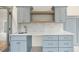 Close up on built in desk area with marble backsplash, oak shelves, and light blue cabinets at 5213 Bent Leaf Dr, Raleigh, NC 27606