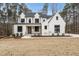 Striking two-story white brick home featuring black trim and a well-manicured lawn at 5213 Bent Leaf Dr, Raleigh, NC 27606
