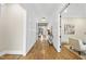 Inviting hallway with wood floors, white wainscoting, and an open view of the living spaces at 5213 Bent Leaf Dr, Raleigh, NC 27606