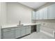 Laundry room with light blue cabinets, countertop, a sink, and neutral flooring at 5213 Bent Leaf Dr, Raleigh, NC 27606