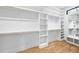 Spacious walk-in closet with custom white shelves, drawers, and a bright window for natural light at 5213 Bent Leaf Dr, Raleigh, NC 27606
