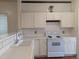 Charming kitchen featuring white cabinetry, tile backsplash, and modern appliances at 5321 Cog Hill Ct, Raleigh, NC 27604