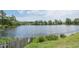 Peaceful lake view with a wooden fence, lush greenery, and serene water at 5321 Cog Hill Ct, Raleigh, NC 27604