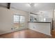 Bright and airy living room with wood-look flooring, large windows, and a view to the kitchen at 5321 Cog Hill Ct, Raleigh, NC 27604