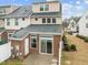 Rear exterior featuring brick, a sliding glass door, and a small patio area at 533 Berry Chase Way, Cary, NC 27519