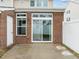 Back patio with brick siding, door, and glass sliding doors at 533 Berry Chase Way, Cary, NC 27519