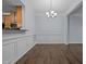 Open dining area with stylish wainscoting, chandelier lighting, and hardwood floors adjacent to the kitchen at 533 Berry Chase Way, Cary, NC 27519