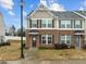 Charming two-story townhouse featuring a brick facade, decorative shutters, and a well-manicured lawn at 533 Berry Chase Way, Cary, NC 27519