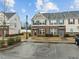 Townhome exteriors with brick and siding details, parking spaces, and landscaped areas at 533 Berry Chase Way, Cary, NC 27519