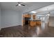 Open-concept kitchen with wood cabinets, black appliances, and flows into a living area with staircase at 533 Berry Chase Way, Cary, NC 27519