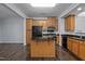 Well-equipped kitchen with dark countertops, wood cabinets, black appliances, and a functional center island at 533 Berry Chase Way, Cary, NC 27519