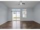 Bright living room features wood floors, a ceiling fan, and a sliding glass door leading to the backyard at 533 Berry Chase Way, Cary, NC 27519