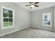 A bright bedroom with two large windows, plush carpeting and a ceiling fan at 5512 Hickory Ln, Raleigh, NC 27603