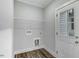 Functional laundry room featuring hookups, shelving, and a doorway to the exterior at 5512 Hickory Ln, Raleigh, NC 27603