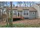 Back exterior view of the home with a wooden deck and lush greenery at 5738 Sentinel Dr, Raleigh, NC 27609
