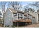 Charming gray home featuring a wooden deck, multiple windows, and beautiful architectural details at 5738 Sentinel Dr, Raleigh, NC 27609