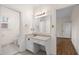Bright bathroom featuring a vanity and sink, framed mirror with lighting, and access to the shower and bedroom at 5738 Sentinel Dr, Raleigh, NC 27609