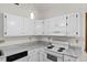Corner kitchen featuring white cabinets, countertops, and stainless steel appliances at 5738 Sentinel Dr, Raleigh, NC 27609