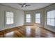 Well-lit bedroom with classic hardwood flooring and three windows at 613 Mclean St, Spring Hope, NC 27882