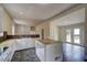 Open concept kitchen with white cabinetry, a center island, tile flooring, and seamless flow to outdoor patio at 613 Mclean St, Spring Hope, NC 27882