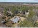 Aerial shot of a charming residence nestled among mature trees in a serene landscape, with a pergola and solar panels at 6336 Wrenwood Ave, Raleigh, NC 27607