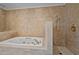 Luxurious bathroom with tiled walls, a jacuzzi tub, shower and gold fixtures for a relaxing experience at 6336 Wrenwood Ave, Raleigh, NC 27607