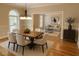 Open dining room with modern lighting fixture, and entryway to living room with hardwood floors at 6336 Wrenwood Ave, Raleigh, NC 27607