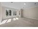 Spacious empty room filled with natural light from large windows, offering a versatile living space at 6336 Wrenwood Ave, Raleigh, NC 27607
