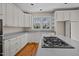 Well-lit kitchen with white cabinets, stainless steel appliances, and a gas cooktop on the island at 6336 Wrenwood Ave, Raleigh, NC 27607
