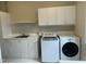 Functional laundry room with sink, storage cabinets, washer, and dryer at 6336 Wrenwood Ave, Raleigh, NC 27607