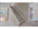 Carpeted staircase with white handrail leading to the upper level, complemented by a window with a brick surround at 6336 Wrenwood Ave, Raleigh, NC 27607
