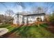 Back of house and yard with large deck and landscaped lawn at 6713 Brookhollow Dr, Raleigh, NC 27615