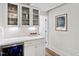 Elegant bar area with glass-front cabinets, wine storage, and granite countertop at 6713 Brookhollow Dr, Raleigh, NC 27615